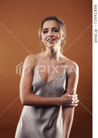young pretty girl with blond hair in dress posing cheerful on brown background, lifestyle people concept young pretty girl with blond hair in dress posing cheerful on brown background, lifestyle people concept 73941898