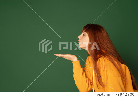 Caucasian woman's portrait isolated on green studio background with copyspace 73942500