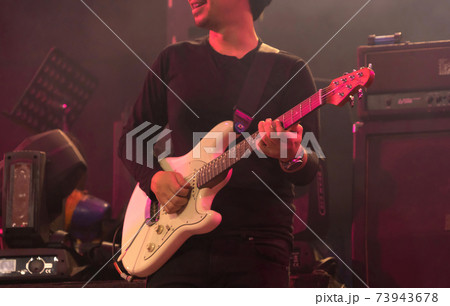 Guitarist man playing electric guitar on a stage playing rock perform on concert and live music in disco pub club bar for party music festival performance. Entertainment nightlife. Celebration event. Guitarist man playing electric guitar on a stage playing rock perform on concert and live music in disco pub club bar for party music festival performance. Entertainment nightlife. Celebration event. 73943678