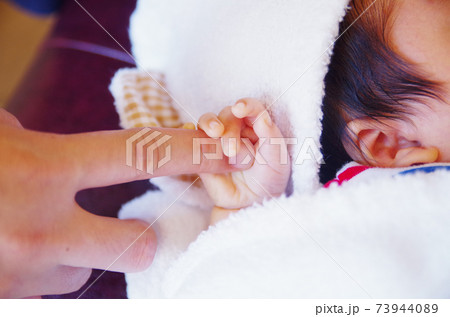 パパの指を握る赤ちゃんの手の写真素材