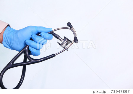 doctor hand in protective gloves holding stethoscope isolated on white  73947897