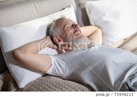 Man lying with hands raised behind head 73948215