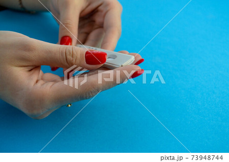disposable pregnancy test strip. girl with red manicure makes a test to determine pregnancy. home diagnostics, in anticipation of the child. gynecological test disposable pregnancy test strip. girl with red manicure makes a test to determine pregnancy. home diagnostics, in anticipation of the child. gynecological test 73948744