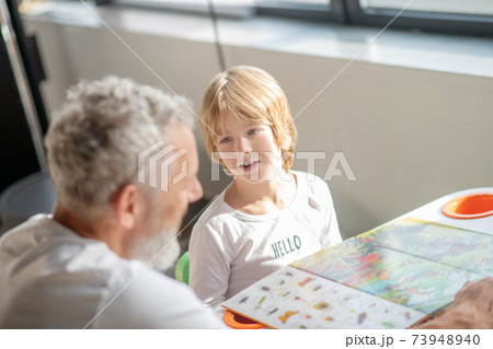 Boy learning animal species while reading a book 73948940