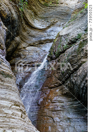 Water flowing or falling down in the waterfall. vertical photo 73950325