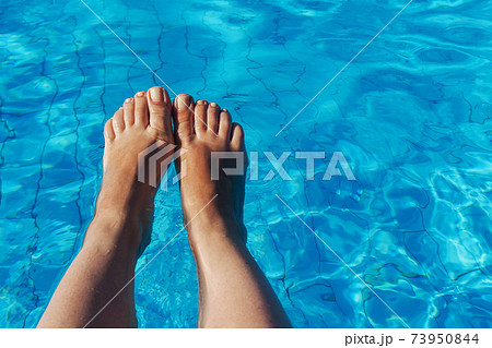 naked female legs on a background of blue water 73950844