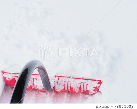 雪かきをする為に雪面へ突き刺したスコップ 73951008
