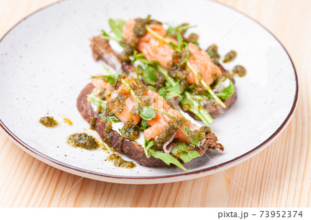 Salmon bruschetta with pesto in white plate 73952374