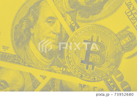 Bitcoins on dollar banknotes background. Gray and yellow tone 73952680