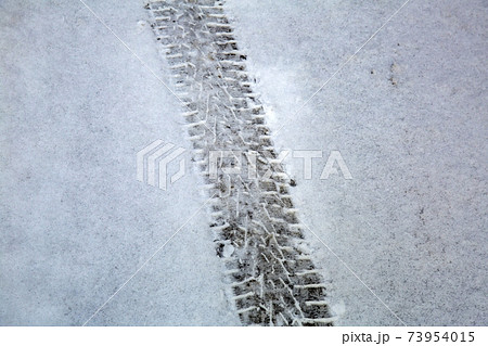 Traces of car wheels on white snow Traces of car wheels on white snow 73954015