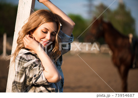 Young cheerful girl with her favorite horse. Young cheerful girl with her favorite horse. 73954687