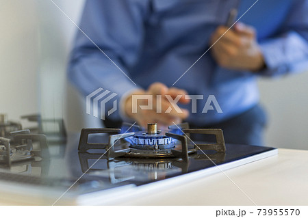 ガスコンロを点検する作業着の男性 73955570