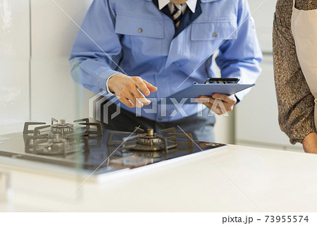 ガスコンロを点検する作業着の男性 73955574