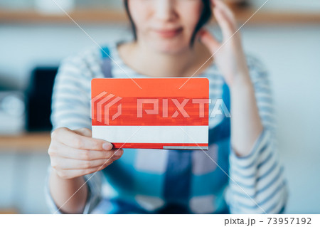 通帳の残高に悩む若い主婦 73957192