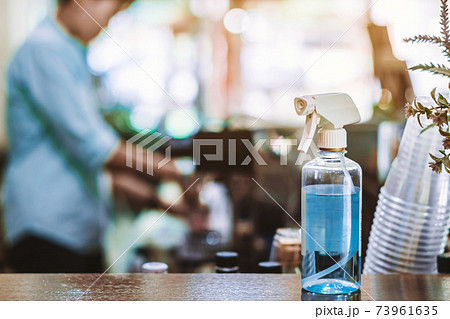 Blue alcohol sprayer bottle for hands cleaning to prevent the spreading of the Corona virus (Covid-19),Place the entrance service for customers  in the cafe. Healthcare concept. New normal lifestyle. 73961635