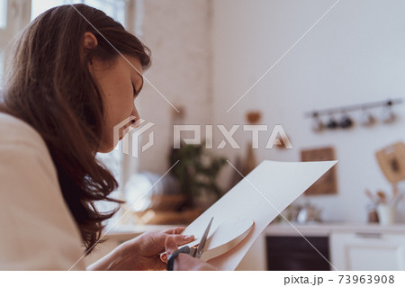 The person cuts the valentine with scissors from the paper. A gift for a sweetheart. Recognition of love 73963908
