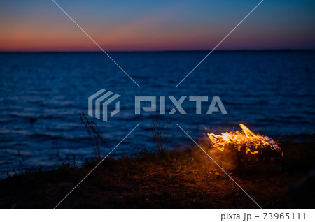 View from a tourist tent on bonfire on the seashore at sunset View from a tourist tent on bonfire on the seashore at sunset 73965111