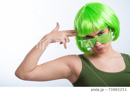Cheerful young woman in green wig and funny glasses celebrating st patrick's day on a white background Cheerful young woman in green wig and funny glasses celebrating st patrick's day on a white background 73965251