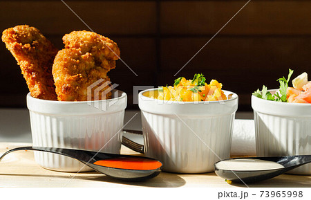 Breaded and herbed chicken breast fillet served with mash potatoes and tomato with onions 73965998