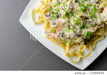 Tagliatelle pasta with smoked pulled ham hock and roasted mushrooms in a cheese sauce 73966046