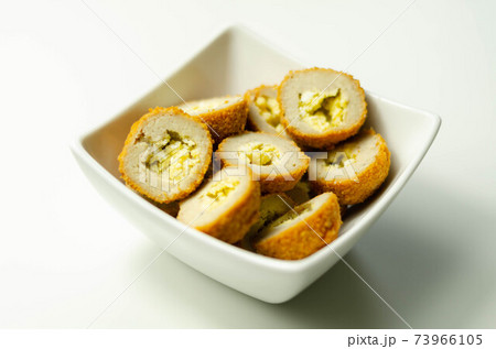 Savory mini scotch eggs in white ceramic bowl, traditional English snack 73966105