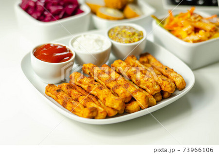 Roast chicken formed in straws, bites of succulent chicken breast with different sauces 73966106