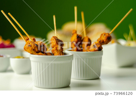 Satay chicken breast marinated in Indonesian style spices and grill on wooden skewers with dip peanut, ketchup, mustard Satay chicken breast marinated in Indonesian style spices and grill on wooden skewers with dip peanut, ketchup, mustard 73966120