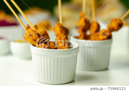 Satay chicken breast marinated in Indonesian style spices and grill on wooden skewers with dip peanut, ketchup, mustard Satay chicken breast marinated in Indonesian style spices and grill on wooden skewers with dip peanut, ketchup, mustard 73966123
