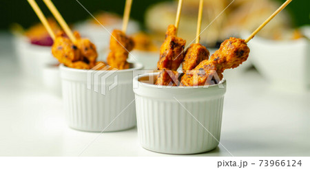 Satay chicken breast marinated in Indonesian style spices and grill on wooden skewers with dip peanut, ketchup, mustard Satay chicken breast marinated in Indonesian style spices and grill on wooden skewers with dip peanut, ketchup, mustard 73966124