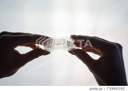 Transparent trays for correcting teeth in female hands. Removable plastic retainers Transparent trays for correcting teeth in female hands. Removable plastic retainers 73966592