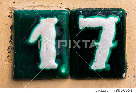 Decorative ceramic house number 17 tile on the wall, characteristic decorative element Decorative ceramic house number 17 tile on the wall, characteristic decorative element 73966652