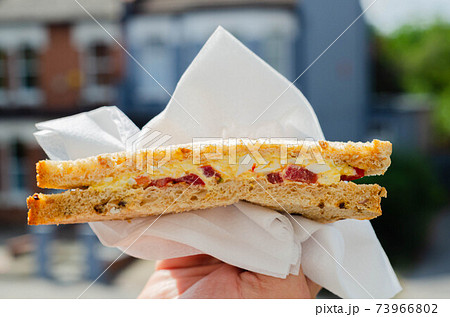 Free range egg mixed with tangy salad cream and slices of sweet tomatoes, all in sandwich malted bread 73966802
