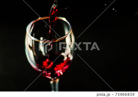 Pouring red wine in a glass, celebration of a moment with a glass of wine, exquisite liquor for gourmets Pouring red wine in a glass, celebration of a moment with a glass of wine, exquisite liquor for gourmets 73966839