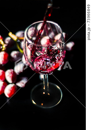 Pouring red wine in a glass, celebration of a moment with a glass of wine, exquisite liquor for gourmets 73966849