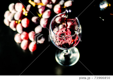 Pouring red wine in a glass, celebration of a moment with a glass of wine, exquisite liquor for gourmets 73966850