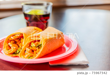 Chicken breast with piri piri sauce and lettuce in a chili tortilla wrap Chicken breast with piri piri sauce and lettuce in a chili tortilla wrap 73967342