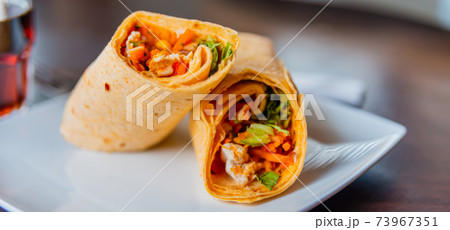 Chicken breast with piri piri sauce and lettuce in a chili tortilla wrap Chicken breast with piri piri sauce and lettuce in a chili tortilla wrap 73967351