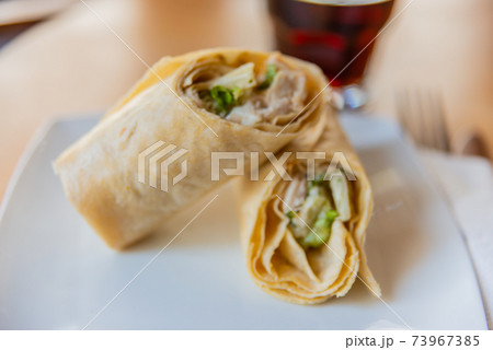 Chicken breast with caesar dressing and lettuce in a gluten-free tortilla wrap Chicken breast with caesar dressing and lettuce in a gluten-free tortilla wrap 73967385