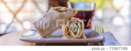 Chicken breast with caesar dressing and lettuce in a gluten-free tortilla wrap 73967386