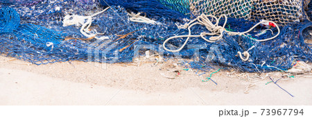 Industrial Fishing Equipment Fishnets and Fishing Lines lying on concrete in the port 73967794