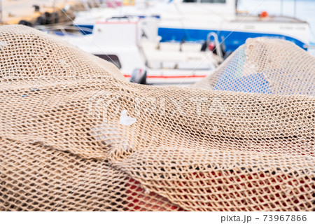 Industrial Fishing Equipment Fishnets and Fishing Lines lying on concrete in the port Industrial Fishing Equipment Fishnets and Fishing Lines lying on concrete in the port 73967866