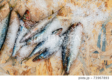 Whole raw organic mackerel fish with sea salt lying on a flat surface Whole raw organic mackerel fish with sea salt lying on a flat surface 73967893