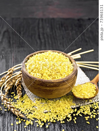 Bulgur in bowl on dark board Bulgur in bowl on dark board 73968131
