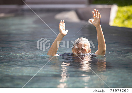 Asian senior people struggling underwater, hand peeking out of the water, female drowned in swimming pool, drowning elderly woman in swimming pool asking for help in dangerous situation 73973266