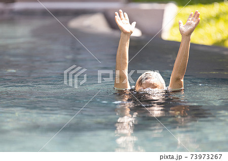 Asian senior people struggling underwater, hand peeking out of the water, female drowned in swimming pool, drowning elderly woman in swimming pool asking for help in dangerous situation 73973267