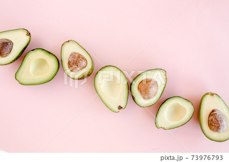 Avocado on pink background. Tropical abstract background with avocado. Food concept. flat lay, top view Avocado on pink background. Tropical abstract background with avocado. Food concept. flat lay, top view 73976793