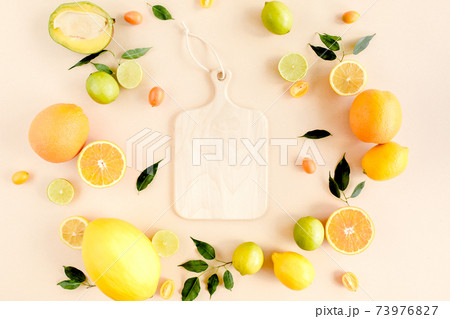 Board frame and summer tropical fruits: orange, lemon, lime, mango on yellow background. Food concept. flat lay, top view Board frame and summer tropical fruits: orange, lemon, lime, mango on yellow background. Food concept. flat lay, top view 73976827