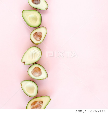 Avocado on pink background. Tropical abstract background with avocado. Food concept. flat lay, top view 73977147
