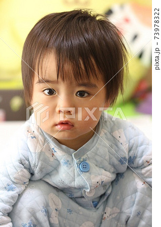 病気で元気のないパジャマ姿の幼児 73978322