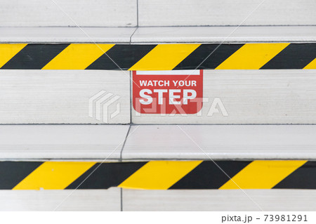 Watch Your Step word signage with yellow black strip on stair steps 73981291